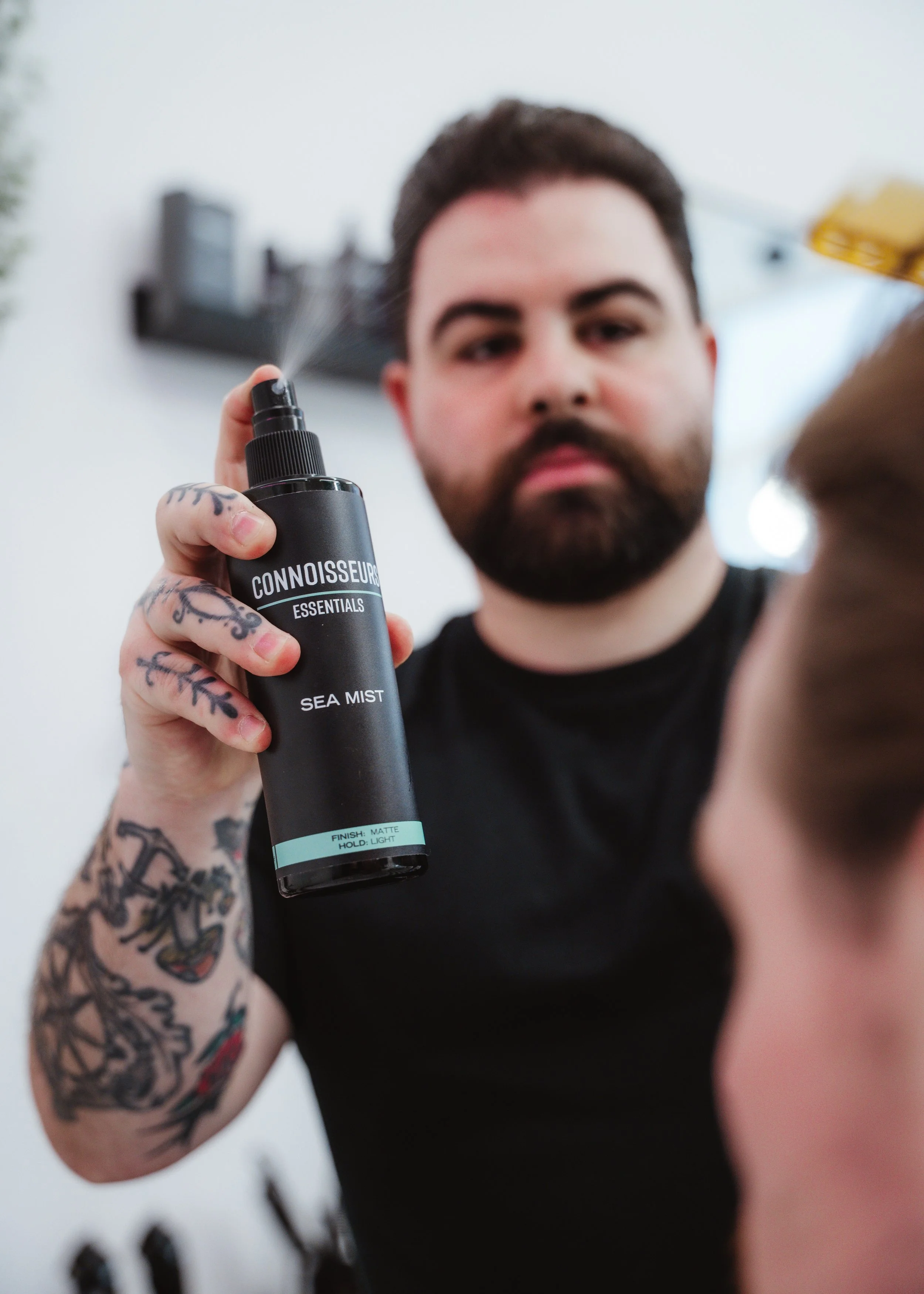 Barber applying Connoisseurs Essentials Sea Mist styling spray at Connoisseurs Barbershop in Leith, Edinburgh