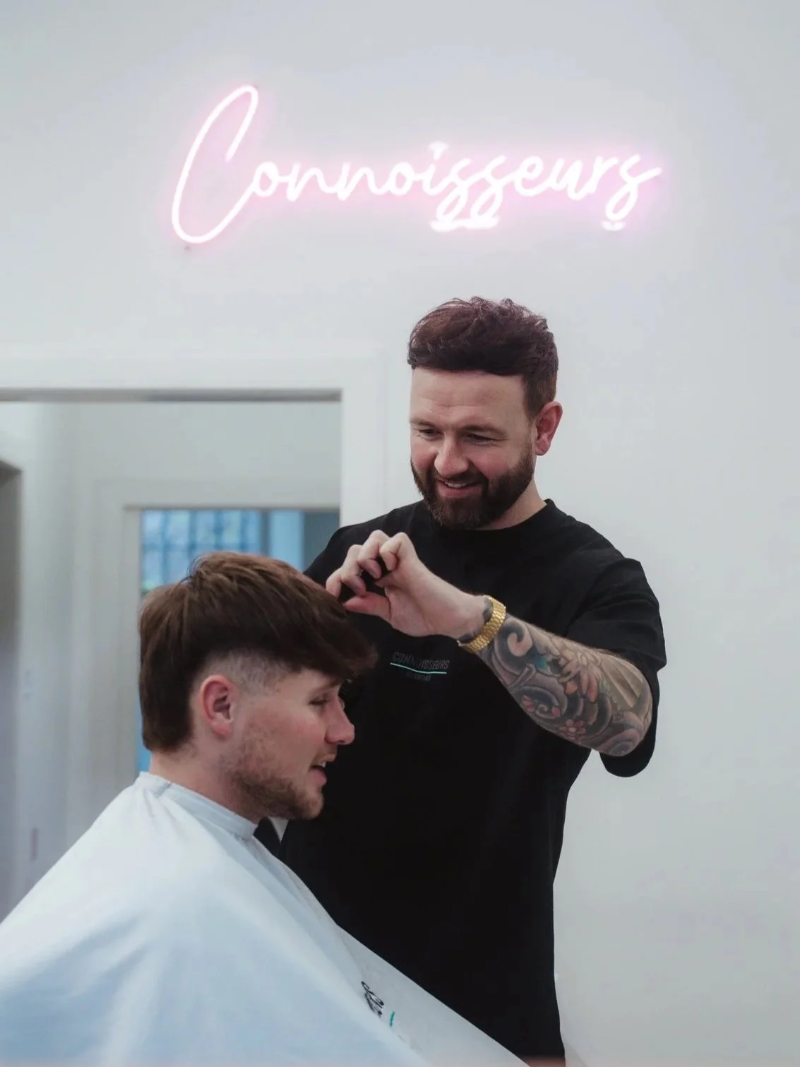 Barber giving a men's haircut at Connoisseurs Barbershop in Leith, Edinburgh