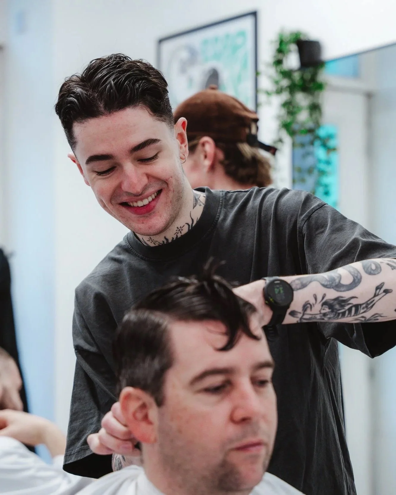 Barber performing a precision scissor cut for a longer men's hairstyle at Connoisseurs Barbershop in Leith