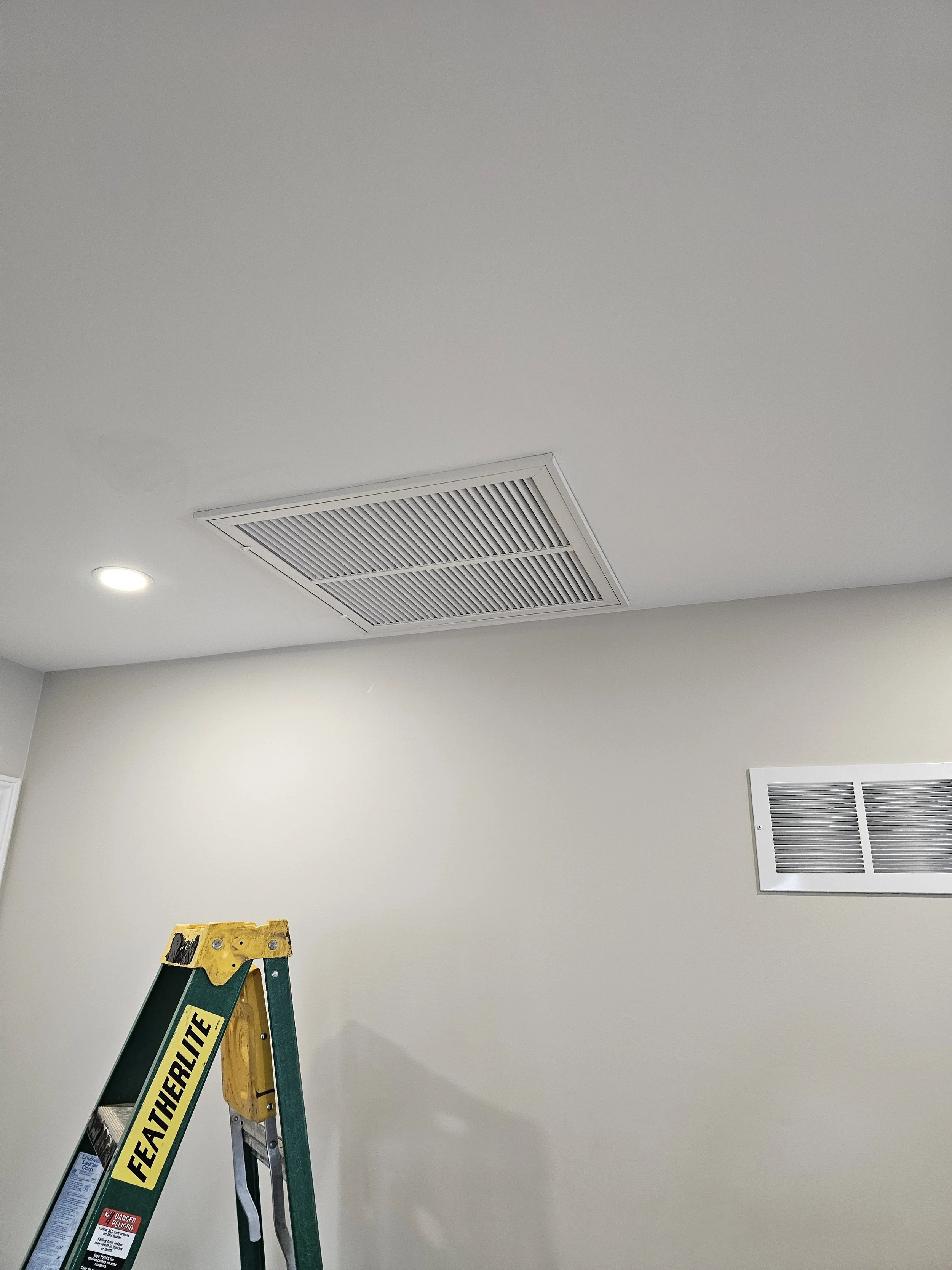 Ceiling with air vents and a small LED light, with a step ladder labeled "FEATHERLITE" in the foreground.