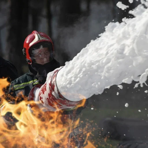 Firefighter spraying with a hose to extinguish a fire.