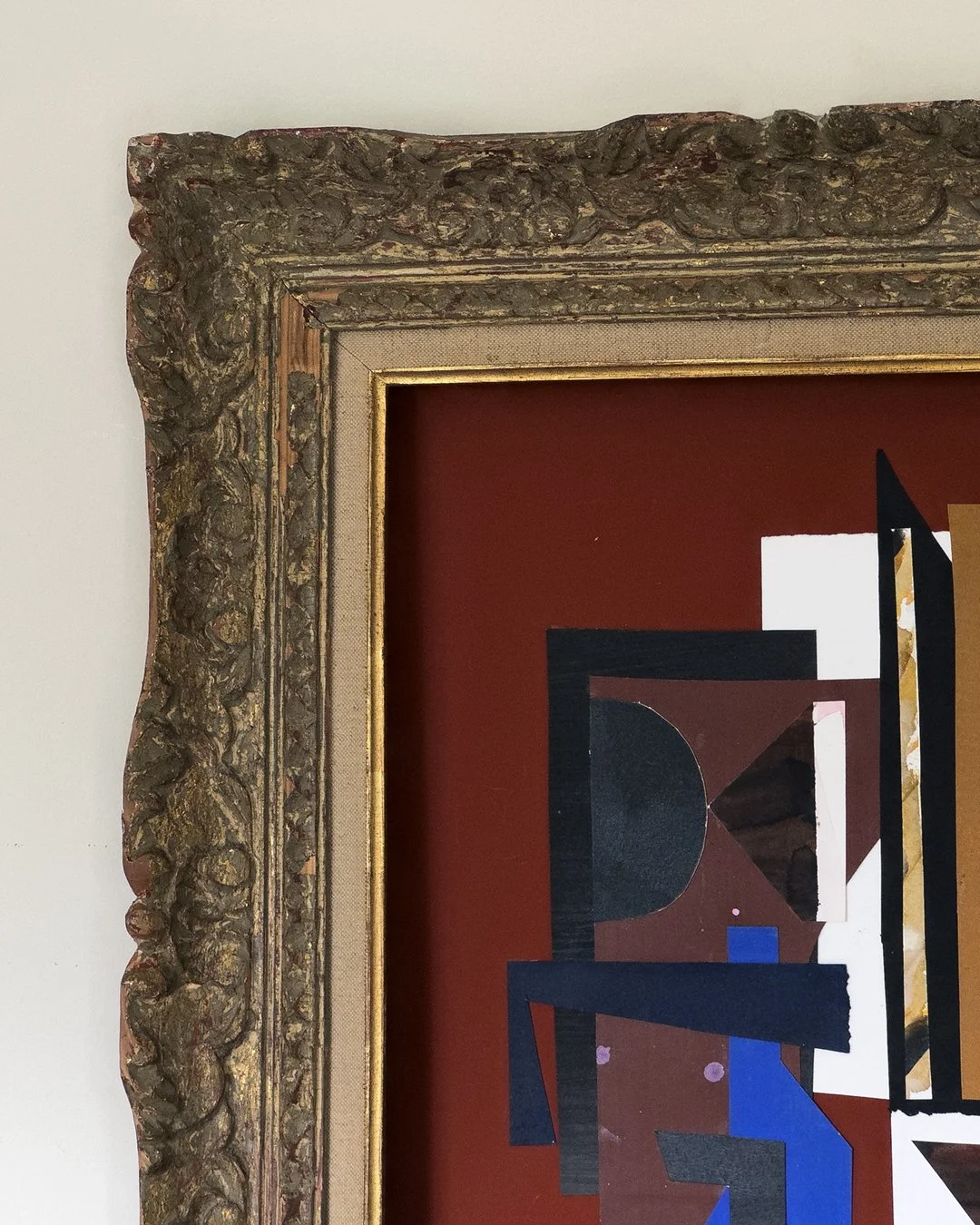 Close-up of a section of an abstract painting with geometric shapes and bright colors, in an ornate gold and carved wood frame.