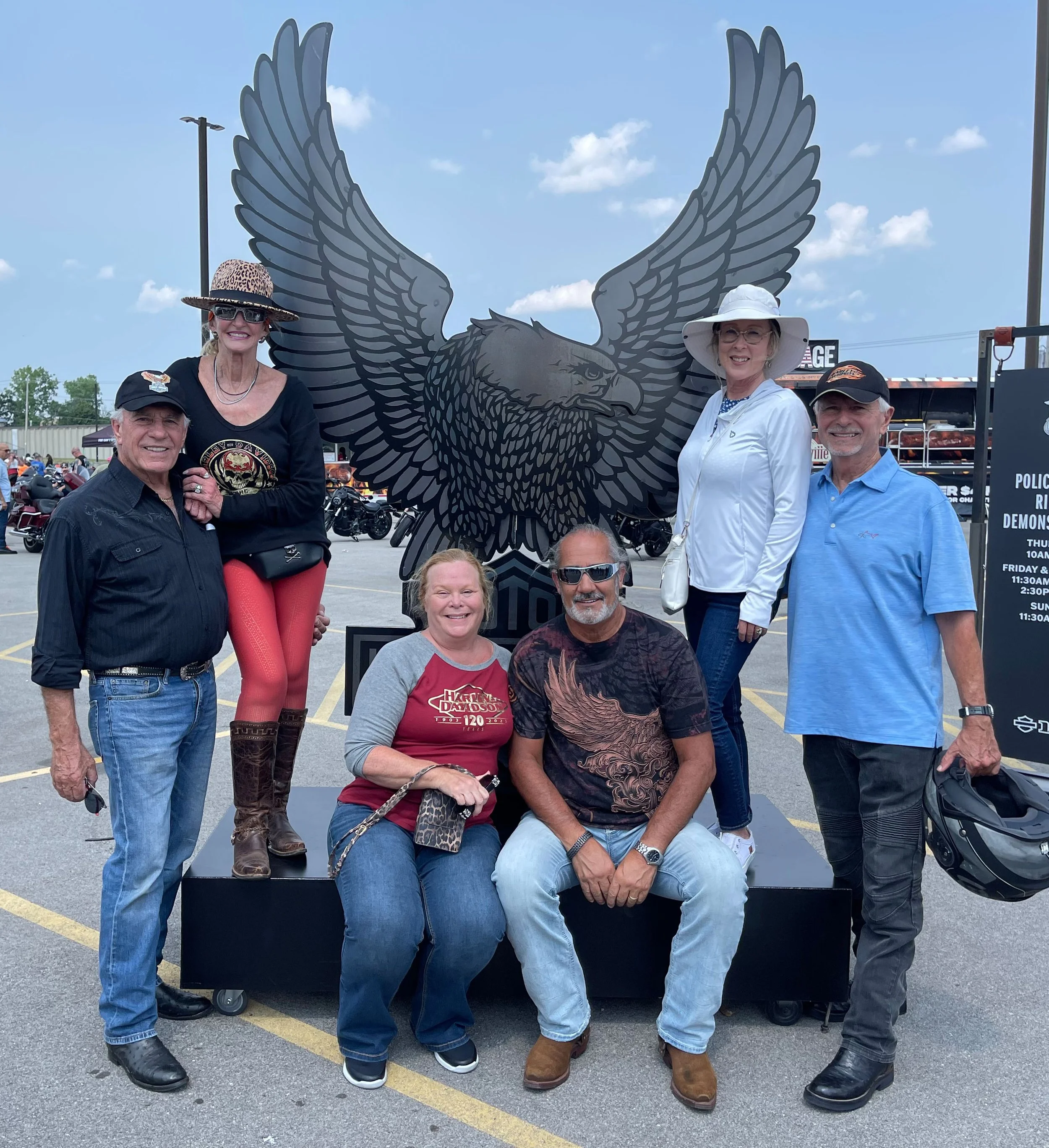 Bus 'n Bikers members in front of a Harley Davidson statue. 