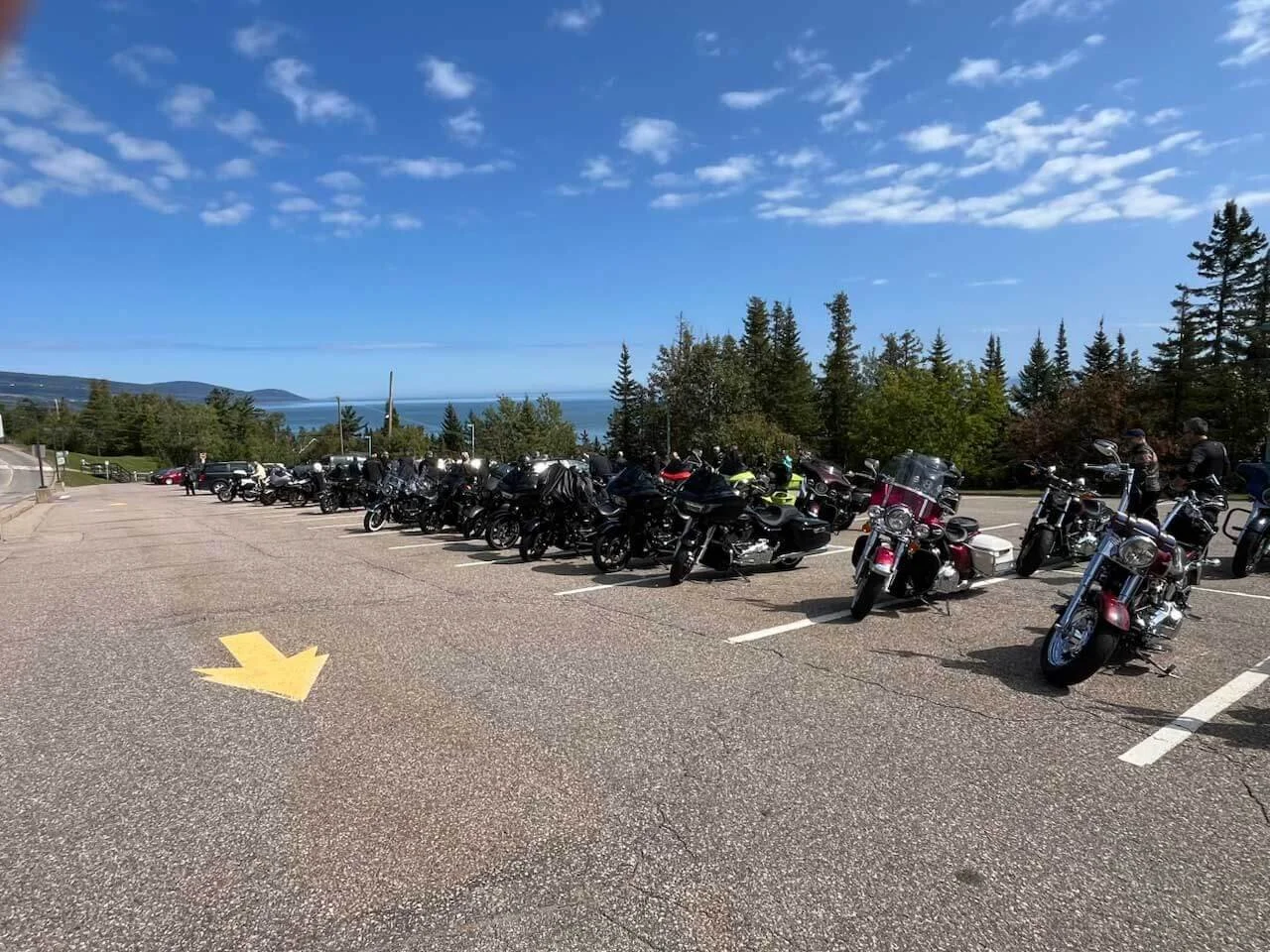 A parking lot overlooking a scenic vista filled with motorcycles during the Prevost 100th Anniversary Rally.