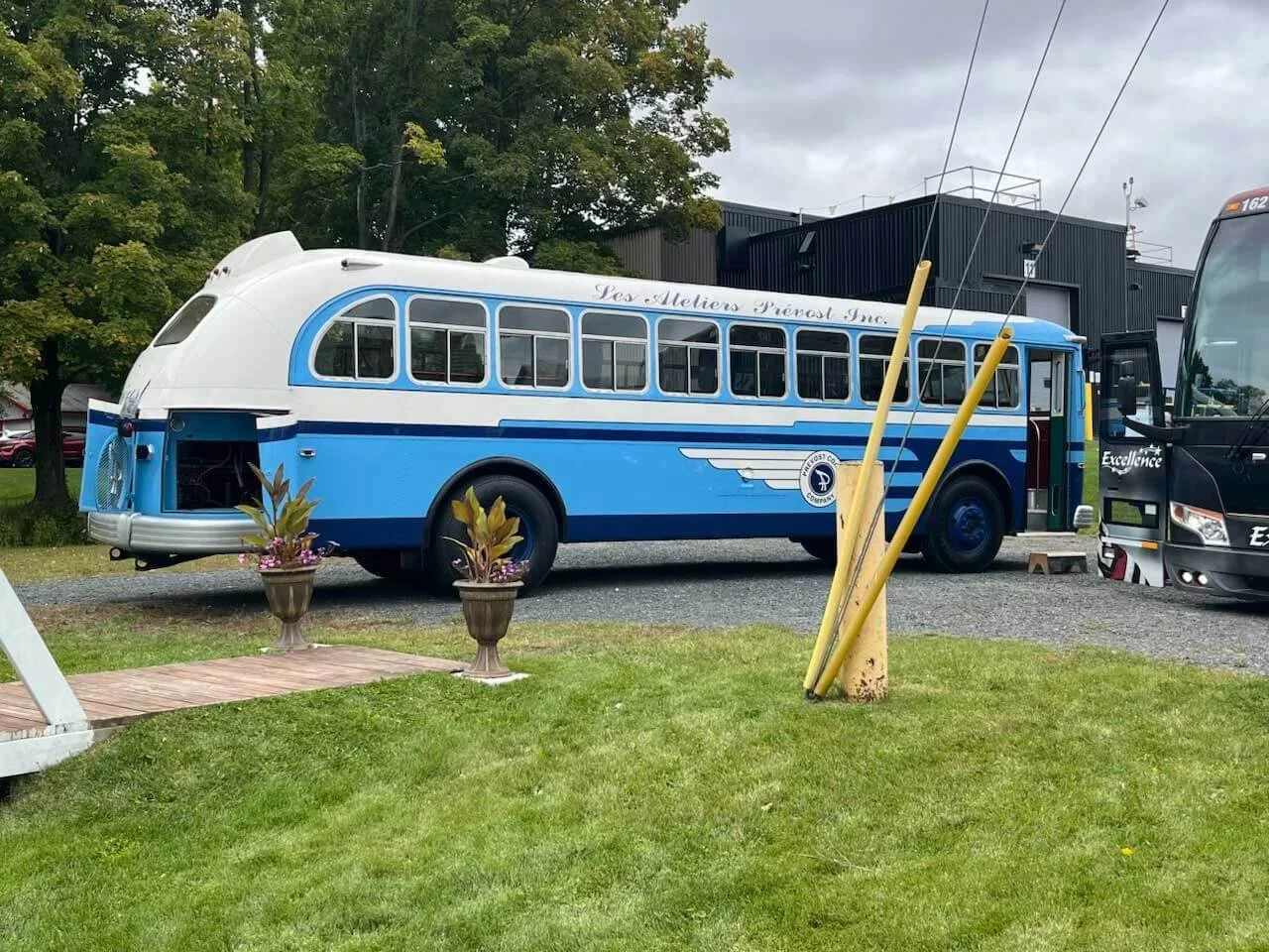 An vintage Prevost bus with a white top and blue bottom. 