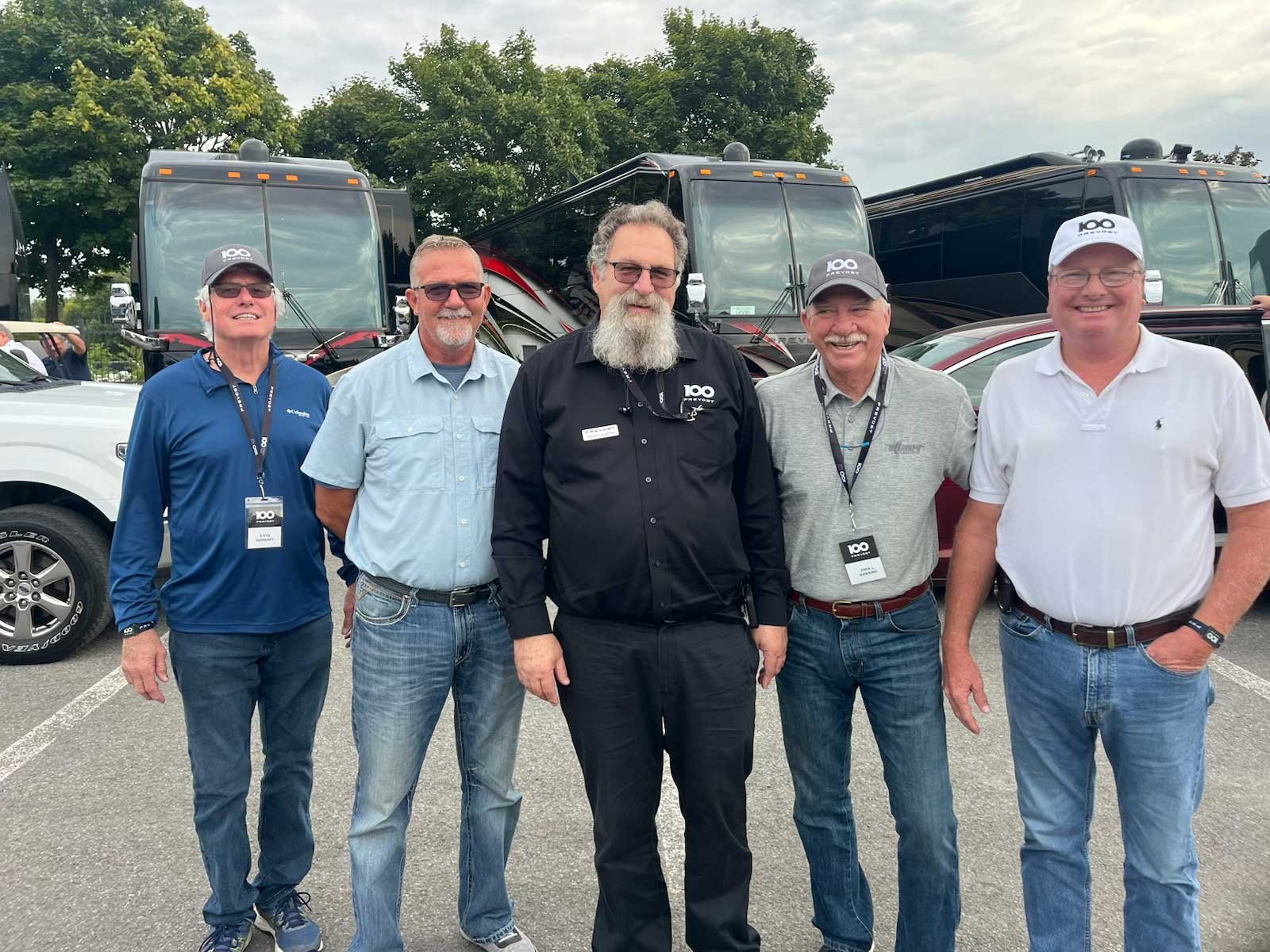 Five Bus n Bikers members in a group shot with luxury coaches