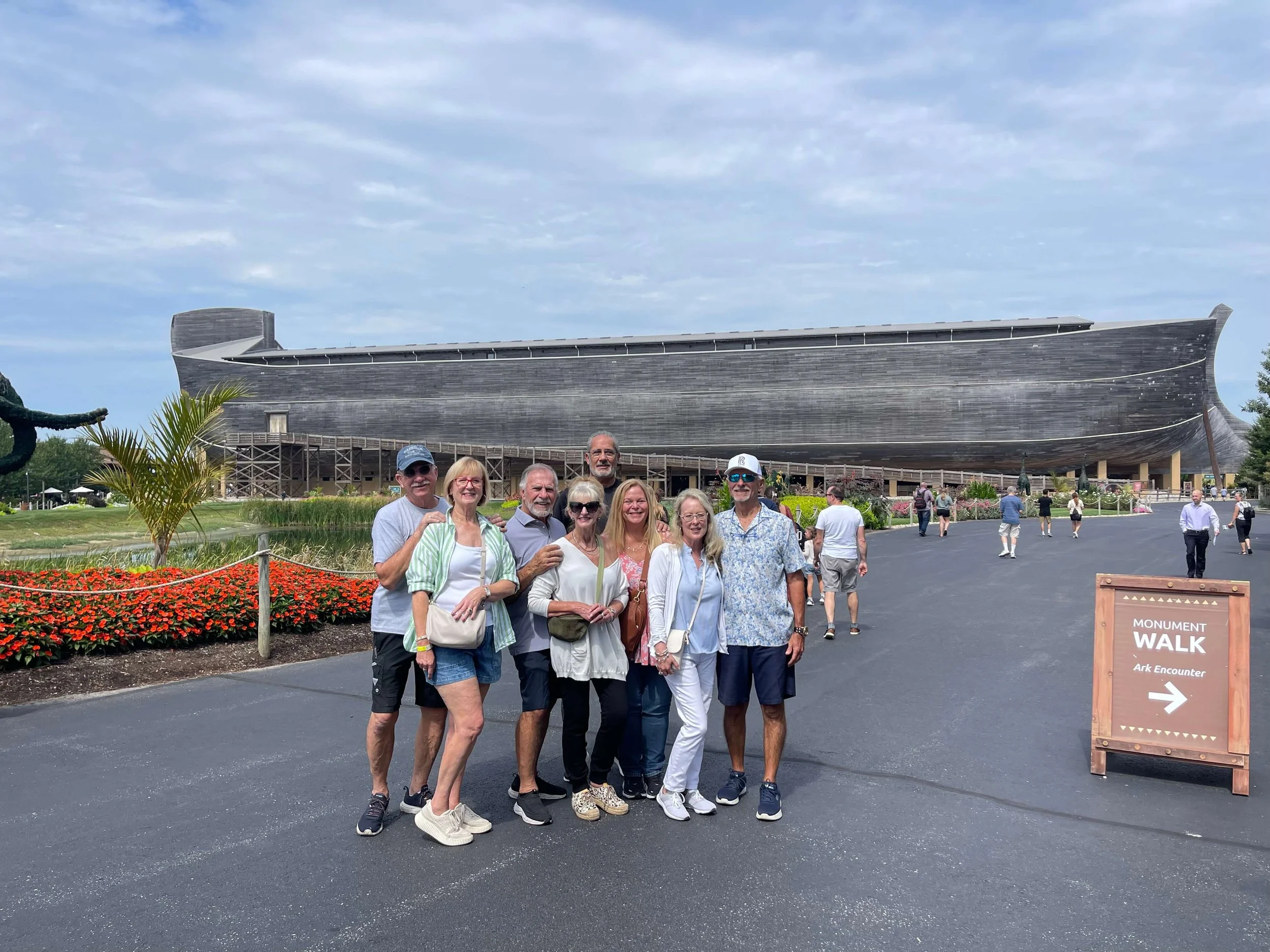 A group of eight people posing for a photo in front of the Ark Encounter.