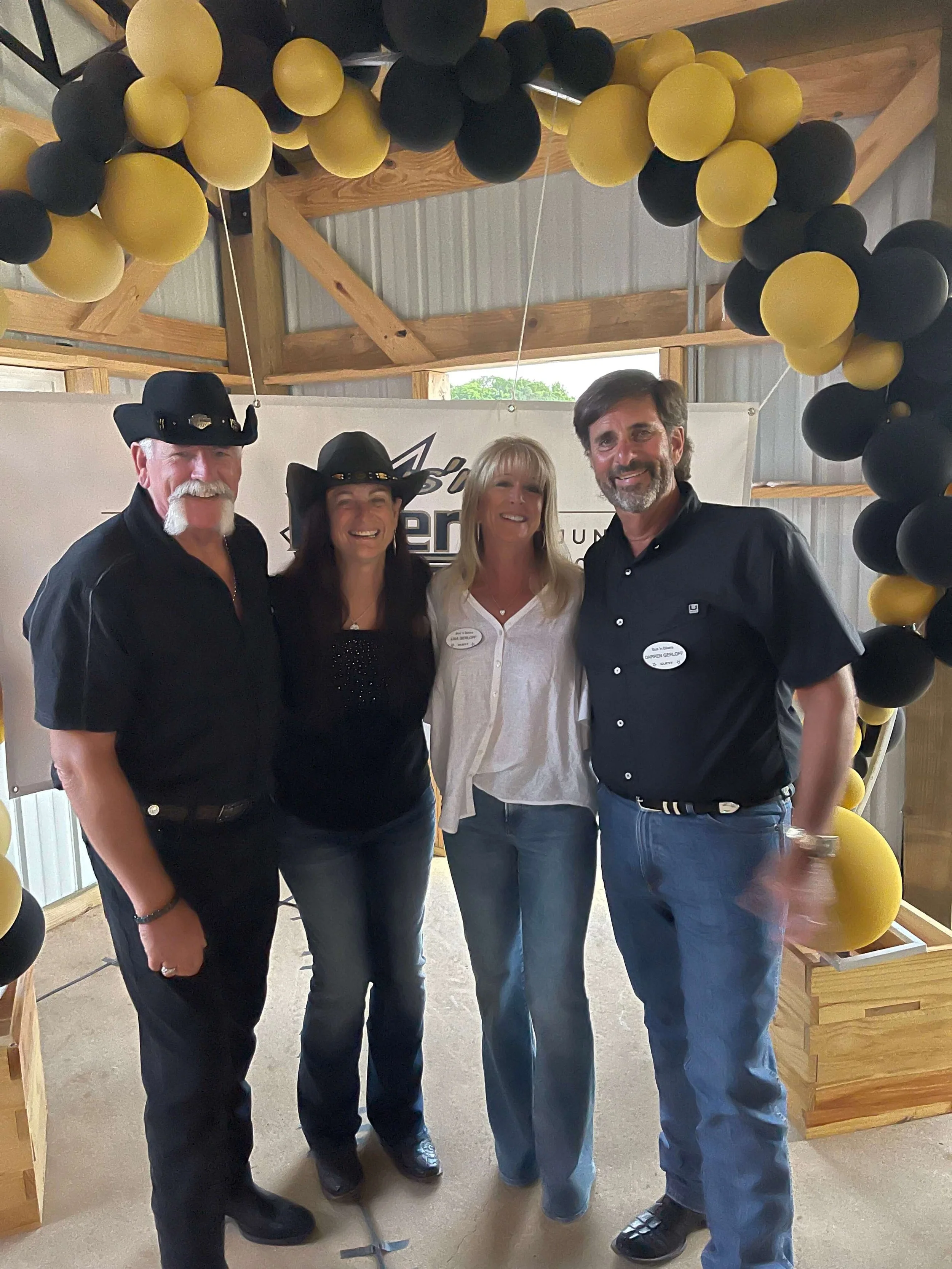 Group of Bus 'n Biker club members posing under a balloon arch at a club event.