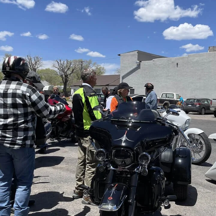 Bus'n Bikers Motorcoach and Motorcycle Club group gathered around Harley-Davidson touring bikes at rest stop.