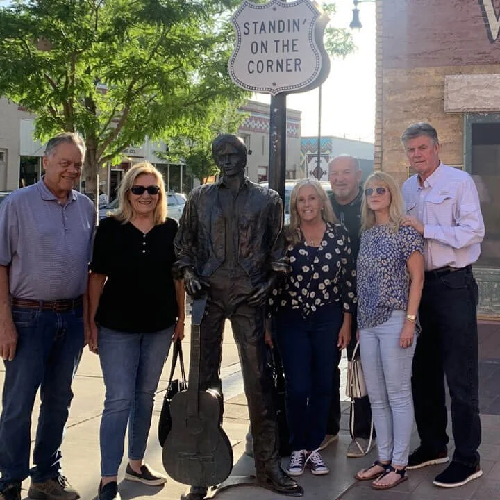 Bus'n Bikers club members posing with Standin' on the Corner statue in Winslow Arizona.