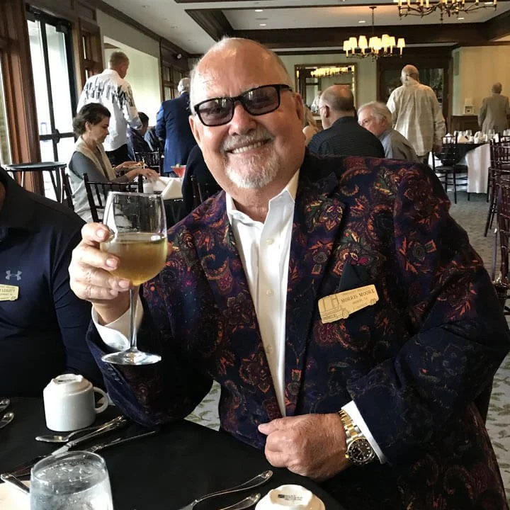 Bus'n Bikers club member in formal attire enjoying cocktail at upscale restaurant during group dining event.