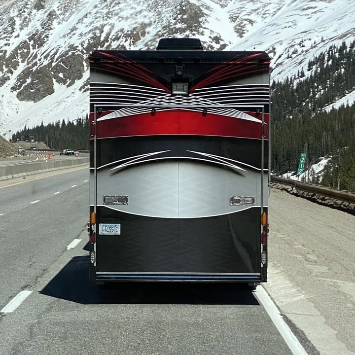 Bus'n Bikers luxury motorcoach traveling through snowy mountain pass.