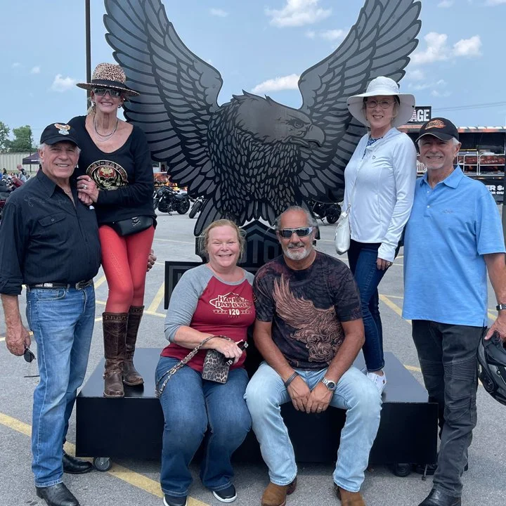 BnB Members posing in front of a Harley Davidson eagle. 