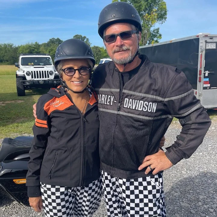 BnB members in Harley Davidson gear in front of their motorcycles. 
