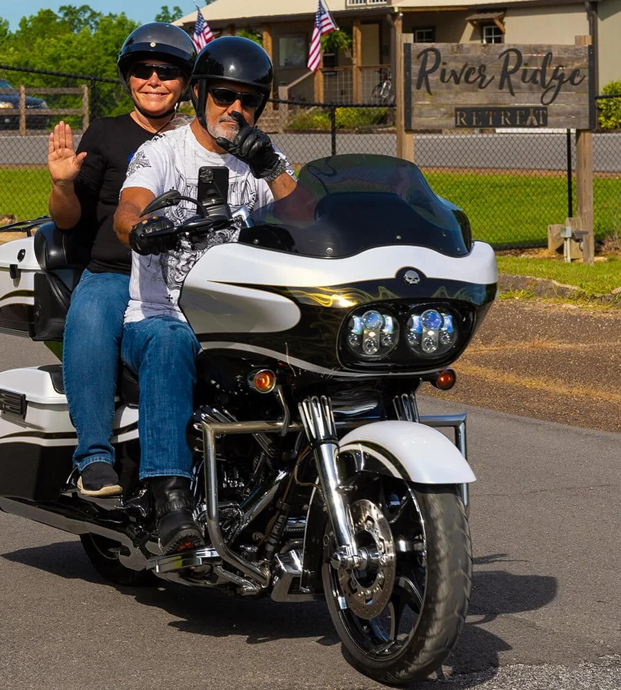 Bus'n Bikers couple riding out waving at the camera.