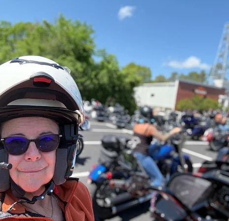 Close-up selfie a rider in a motorcycle helmet at a crowded Eureka Springs Harley-Davidson.