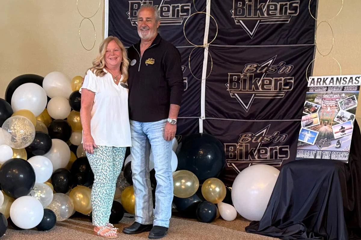 smiling together at the Bus n Bikers Rally masters smiling at Spring 2026 Ozarks rally event banner.