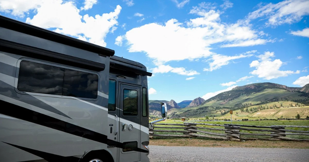 A luxury Class A motorcoach parked at a scenic RV resort in Creede, Colorado.