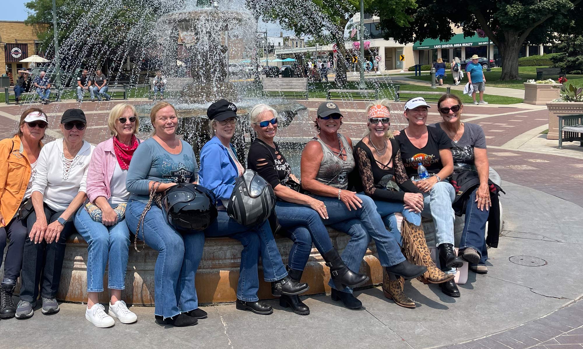Bus'n Bikers female members sitting on a fountain in Lake Geneva.
