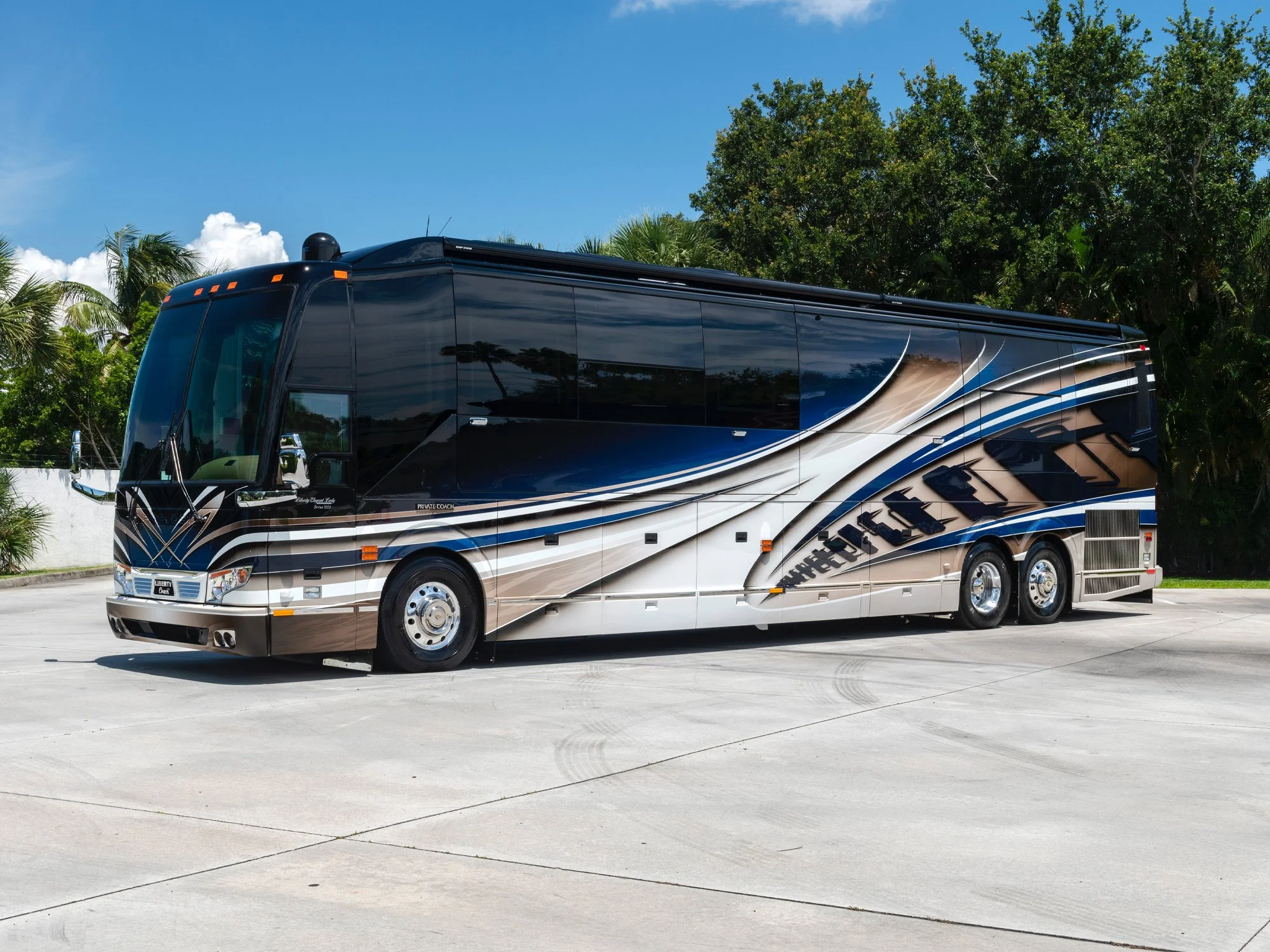 Liberty Coach luxury motorcoach parked outdoors with custom blue and silver exterior paint design.