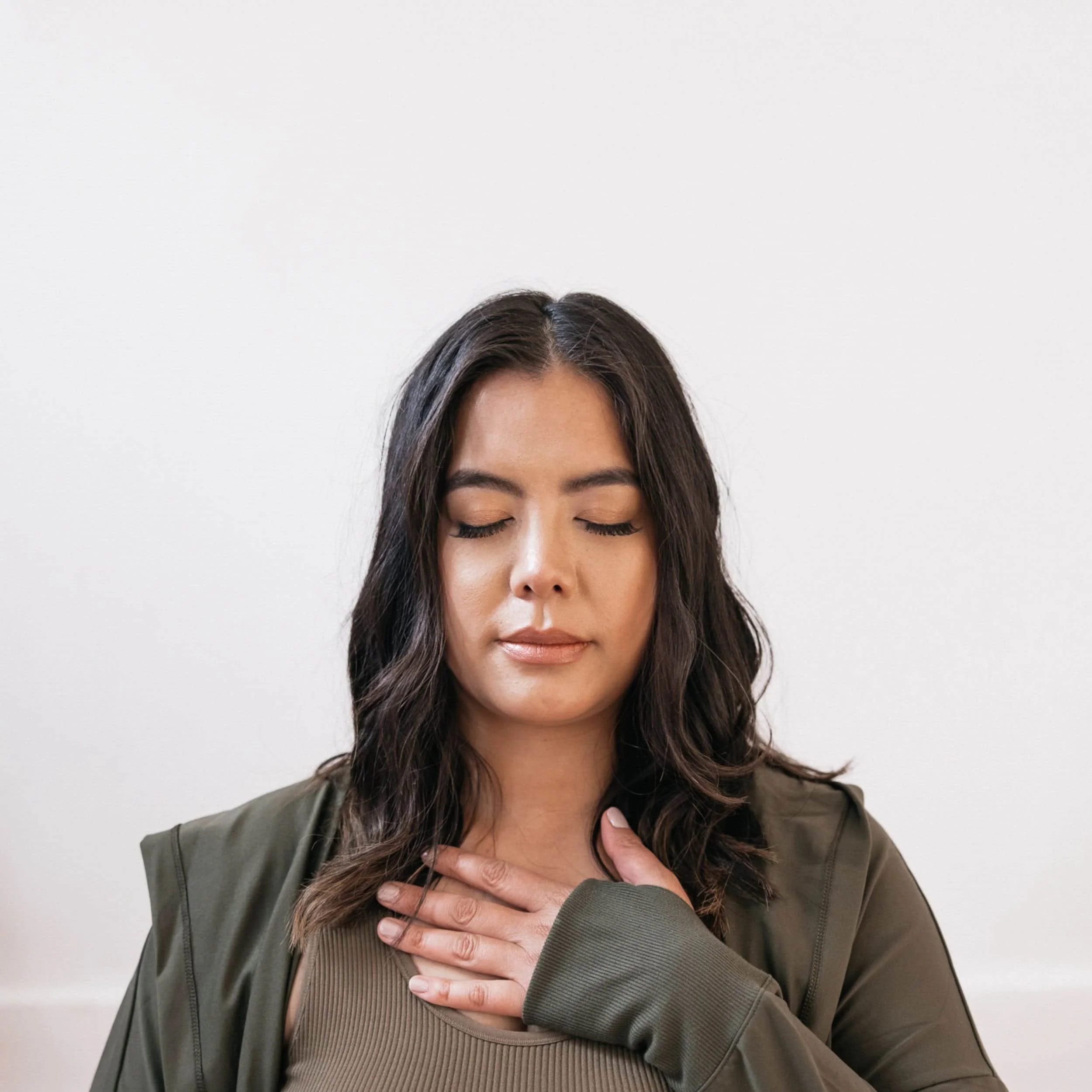A woman wearing green places her hand on her heart during a decolonization workshop in Minneapolis, Minnesota