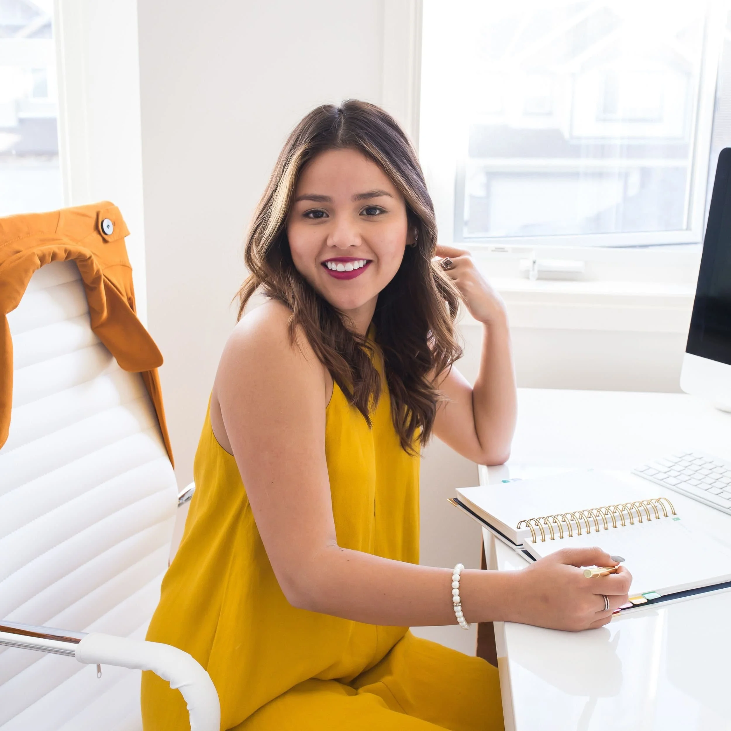 Woman in yellow dress smiles after completing a career transition