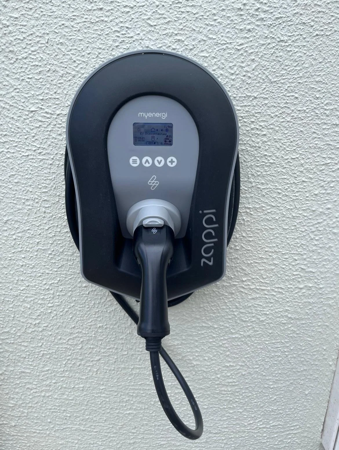Electric vehicle charging station mounted on a white textured wall.