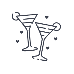 Two martini glasses with olives, surrounded by small hearts and confetti.