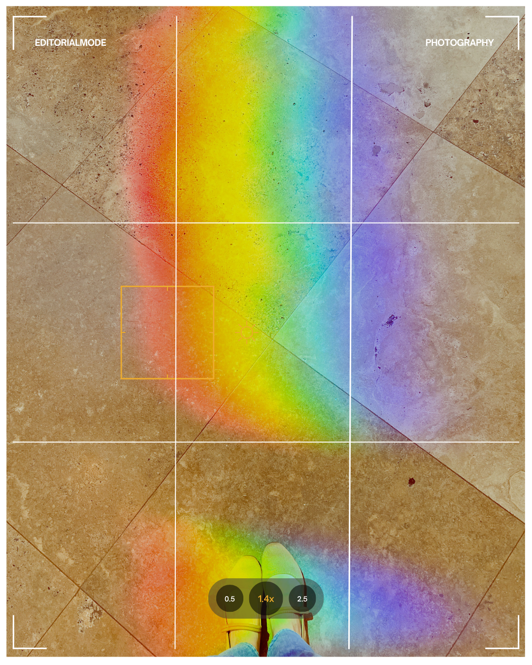 A person standing on a tiled floor at sunset with rainbow light reflecting on the ground, captured through a camera viewfinder overlay.