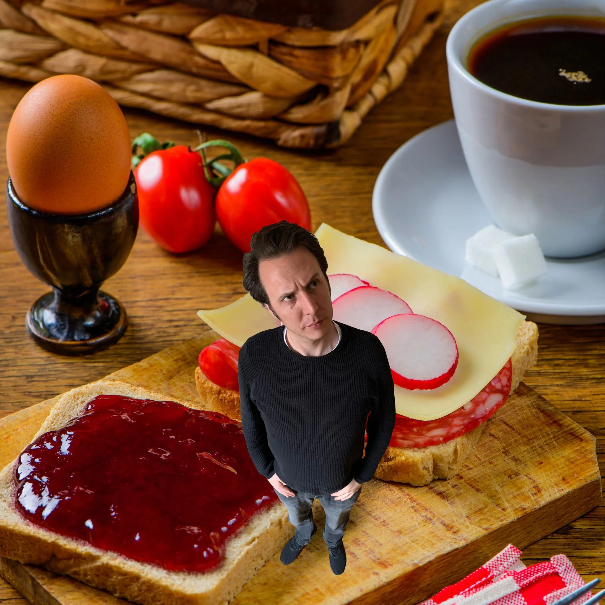 A man stands in front of a breakfast spread that includes toast with jam, cheese, slices of radish, cherry tomatoes, a boiled egg, and a cup of coffee on a wooden table.
