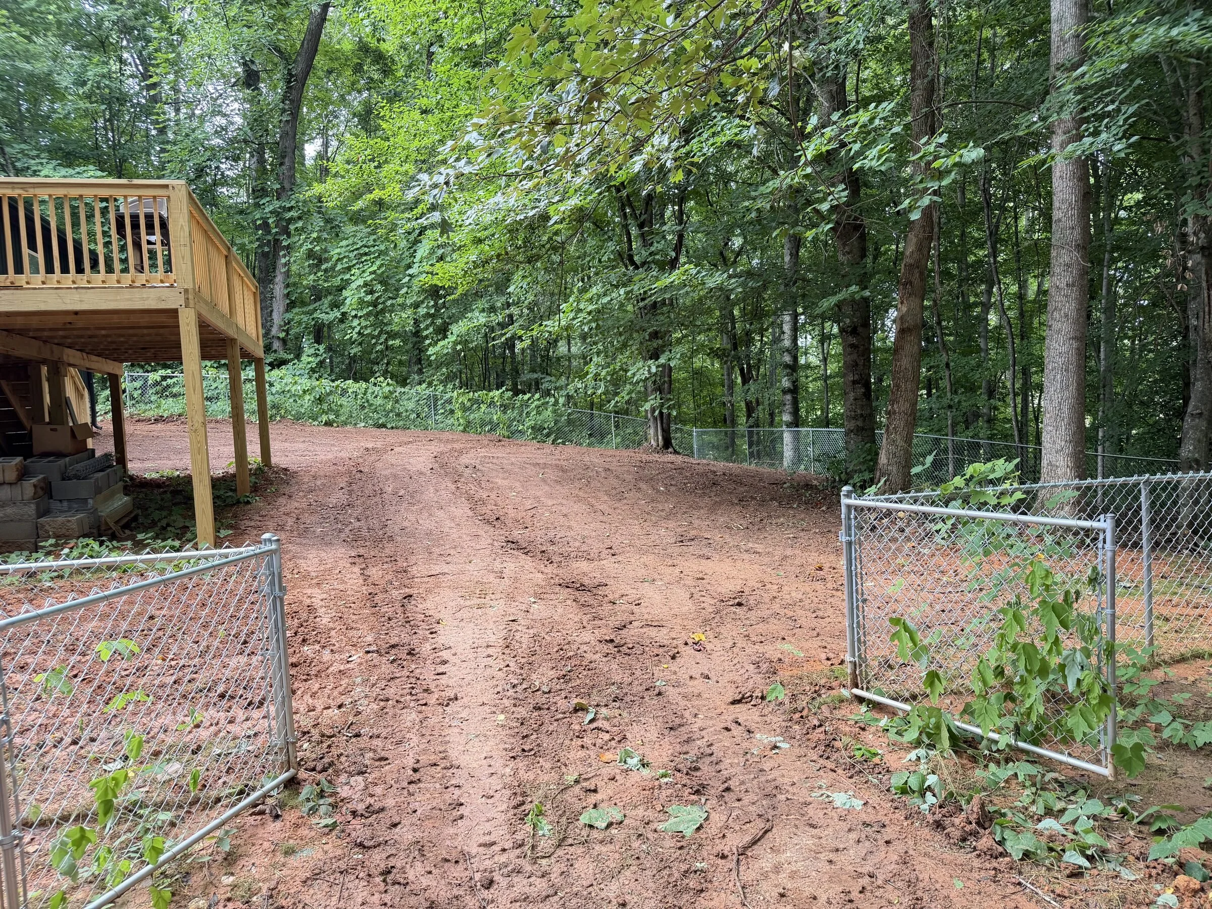 Red clay driveway graded through wooded lot in Sparta, TN