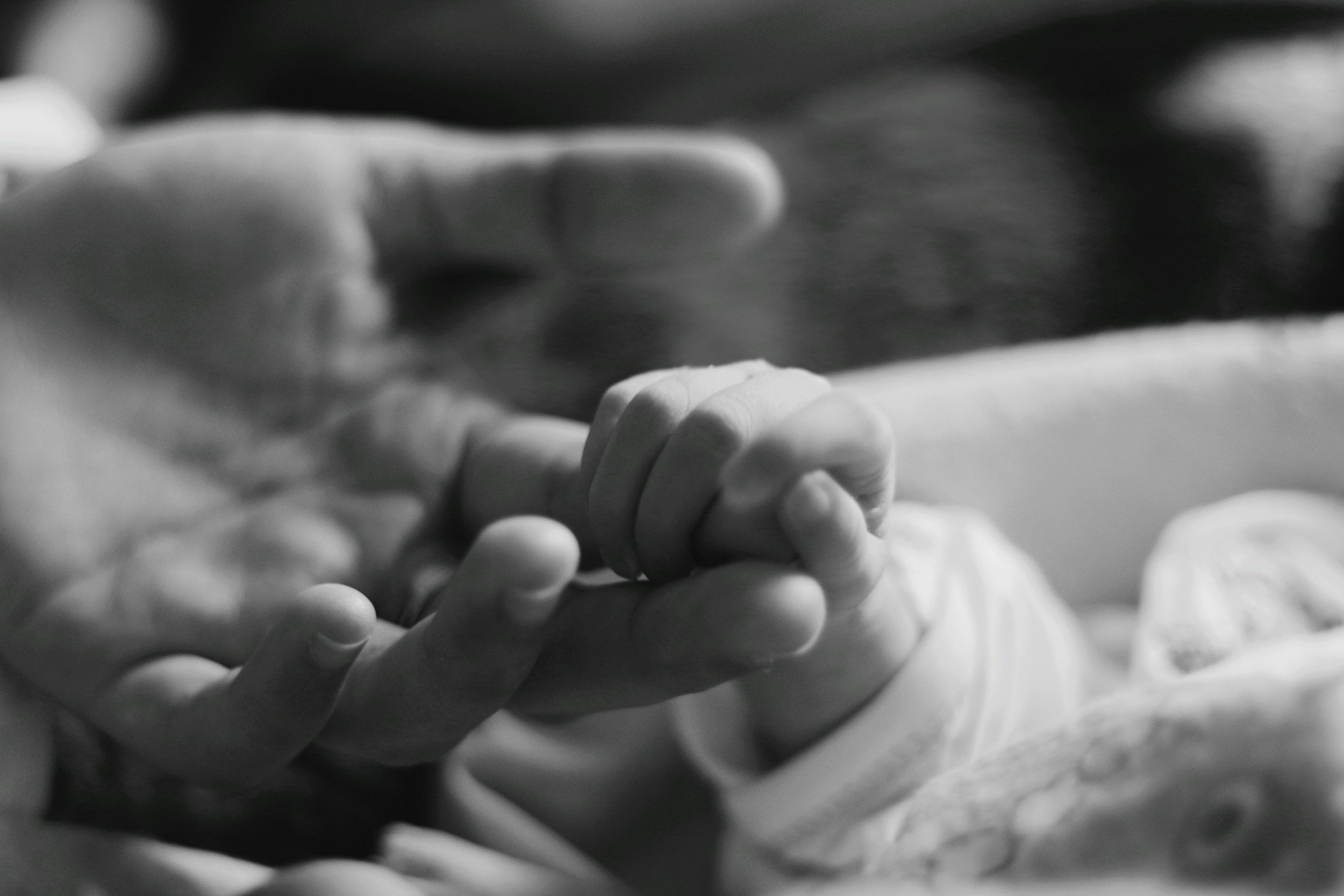 a photo of a baby holding mom's finger after the mom attends therapy in Didsbury, Alberta