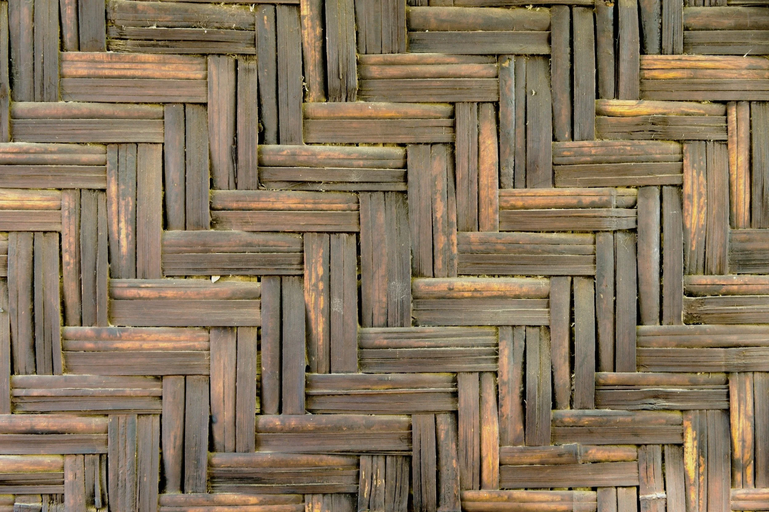 Close-up of woven wooden lattice made of dark brown slats.