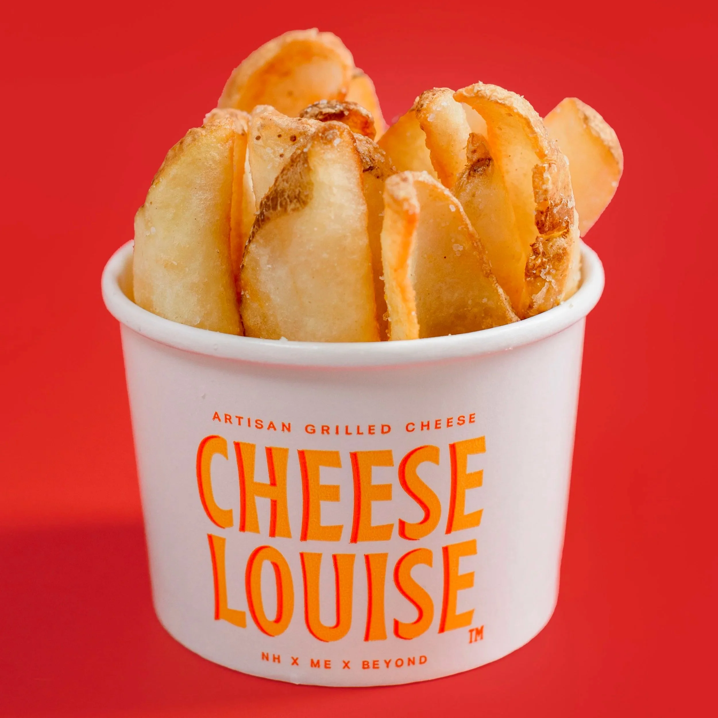 Cup of French fries in a white container labeled 'Cheese Louise' with orange text, against a red background.