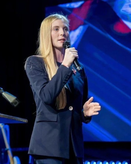 Chelsey Gray speaking on stage with a microphone