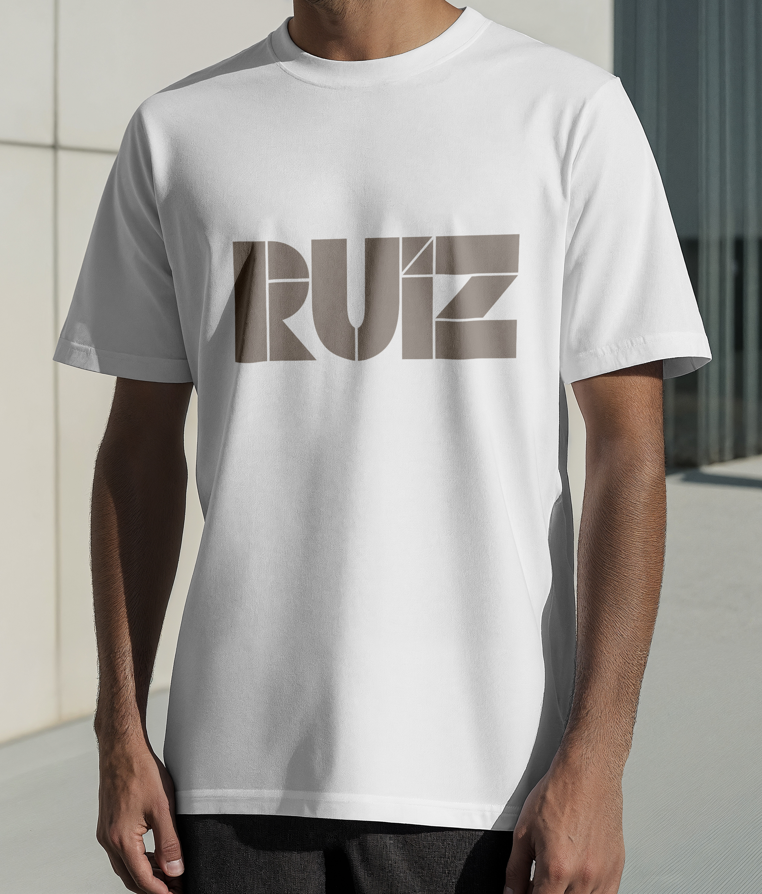 A man wearing a white t-shirt with the word 'RUZ' printed on it in large block letters.