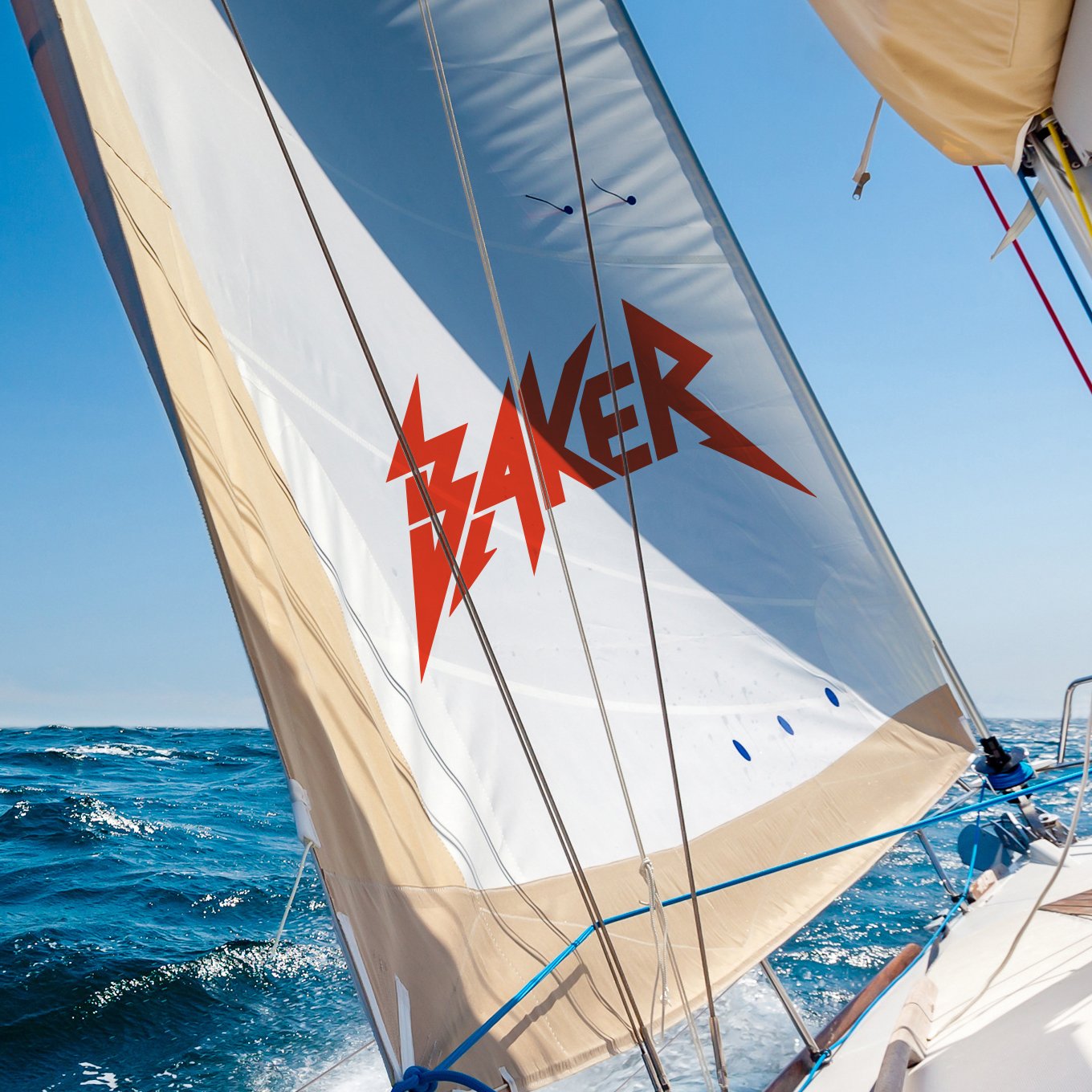 A sailboat on the water with a sail that has the word 'Shaker' written in red with lightning bolt designs.