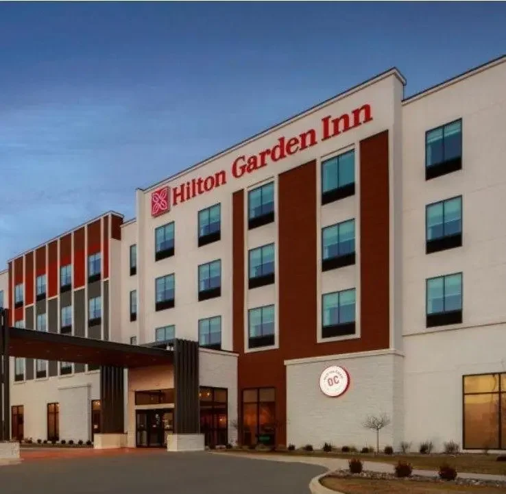 Exterior view of Hilton Garden Inn hotel with its sign visible at the top of the building.