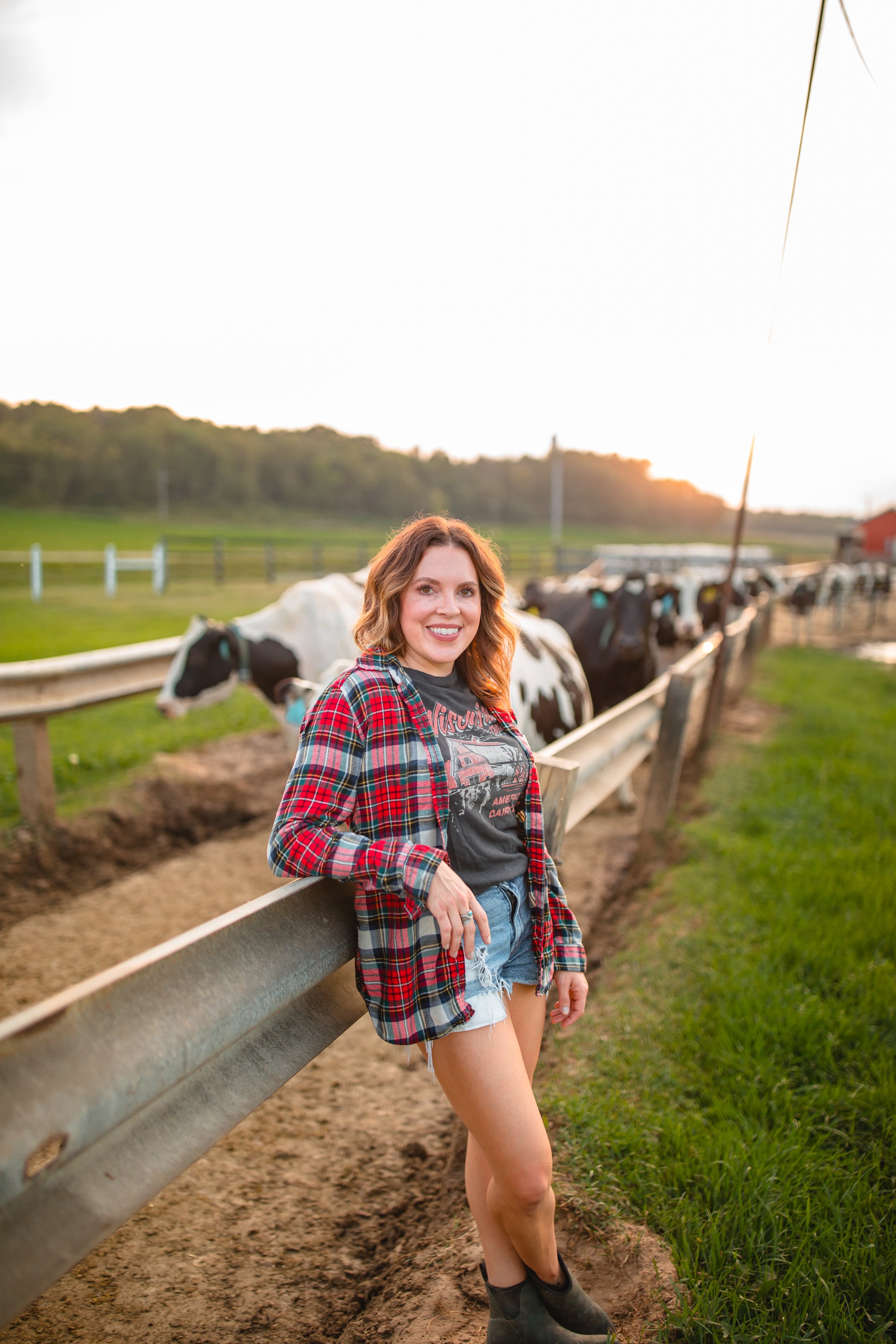 Woman standing in front of black and white cows