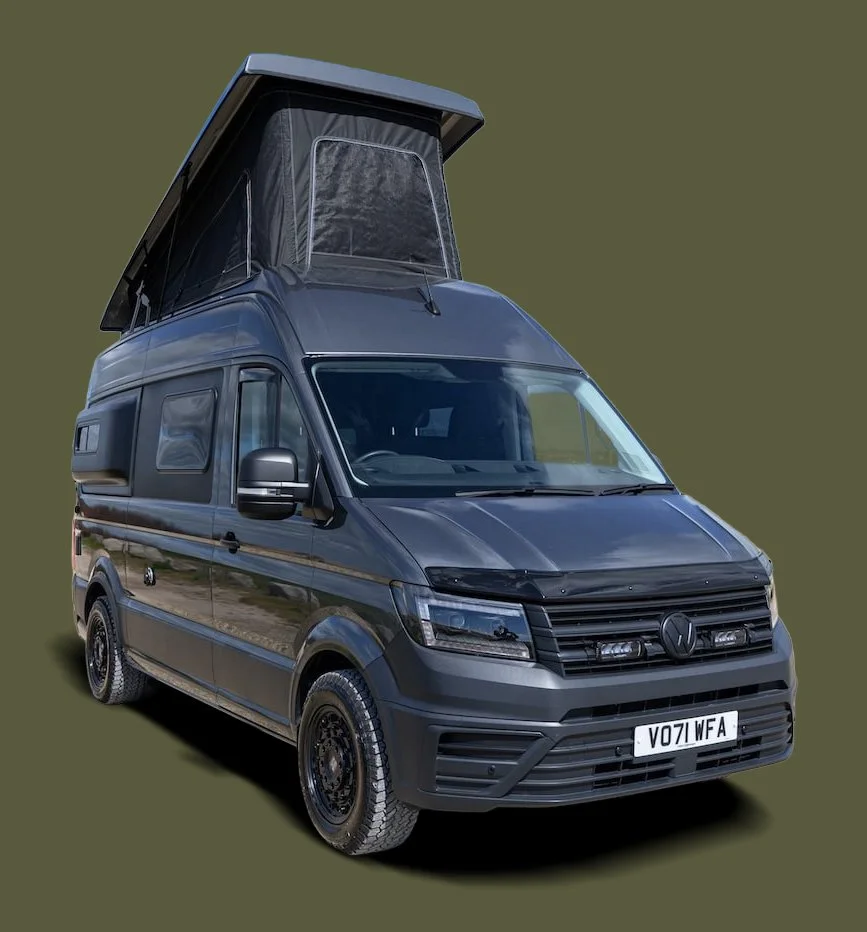 Black camper van with a pop-up roof on a green background.