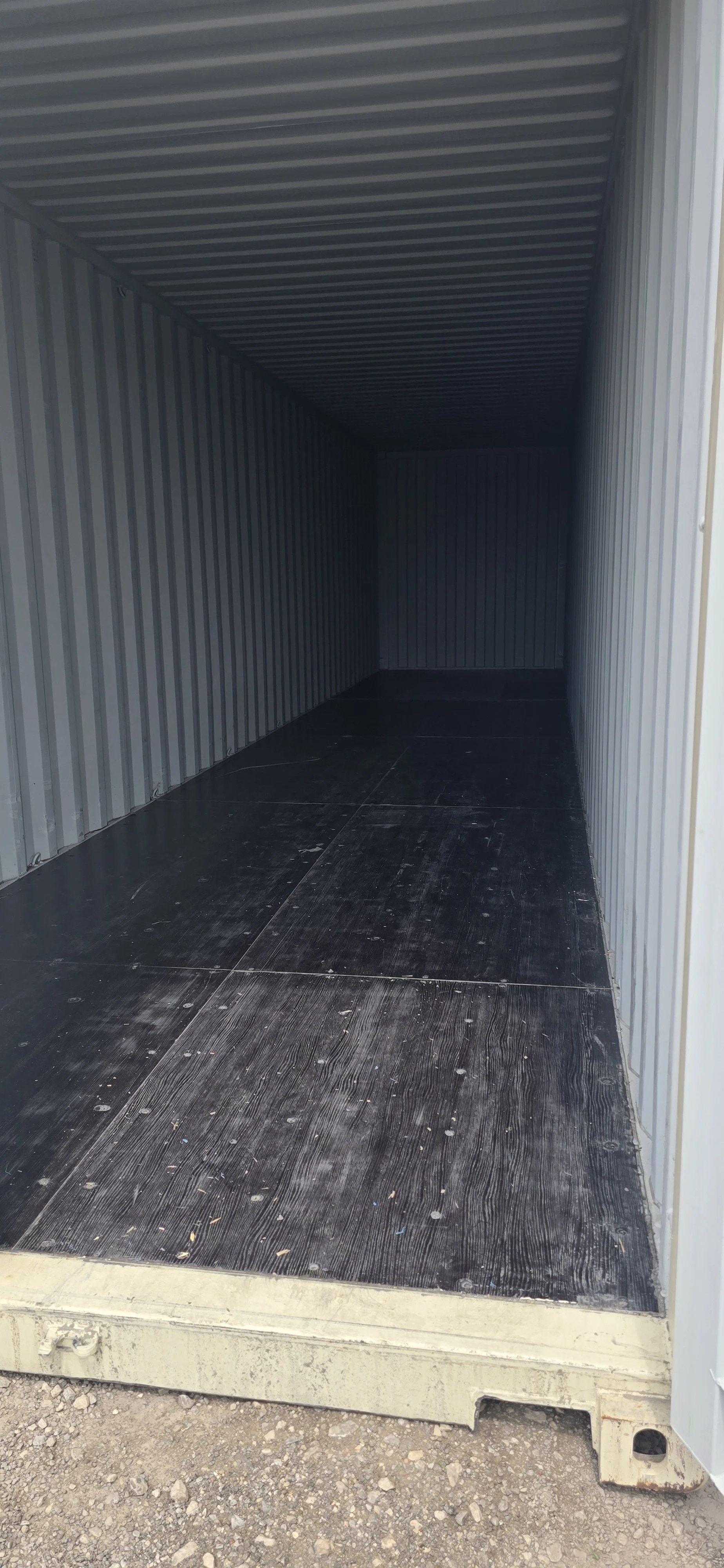 Interior of 40 ft one trip shipping container with one door open and wood flooring