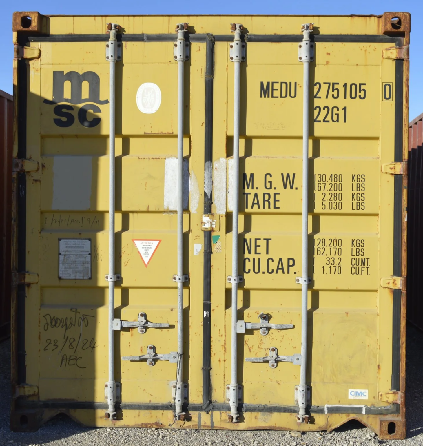 Front view of a used 20 ft shipping container for sale in Fort Worth, Texas featuring secure double doors, steel locking bars, and weathered exterior.