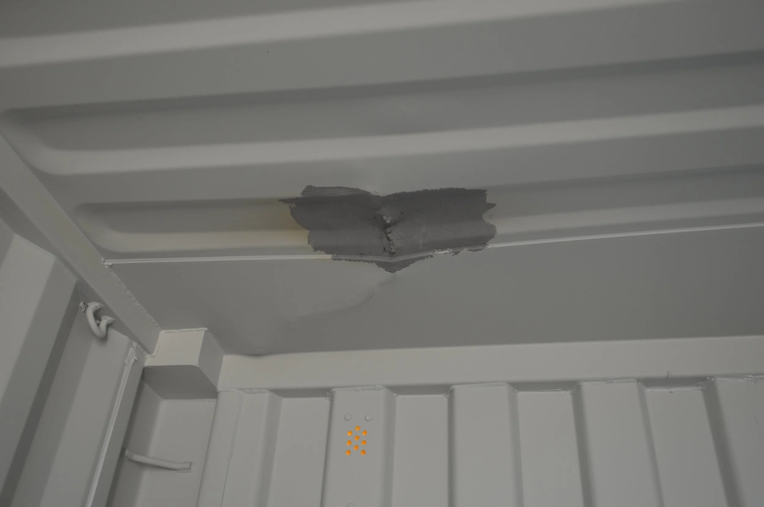 Interior ceiling of a one trip 20 ft storage container showing previously repaired roof damage, sealed and reinforced for weather protection.