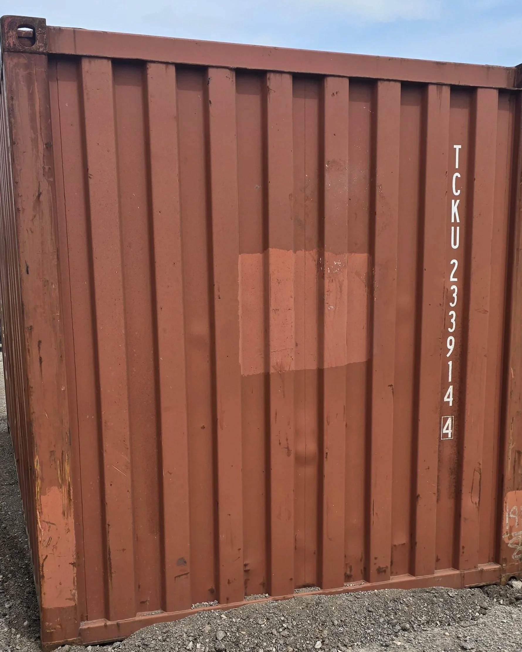 Rear view of brownish red 20ft shipping container showing solid steel structure