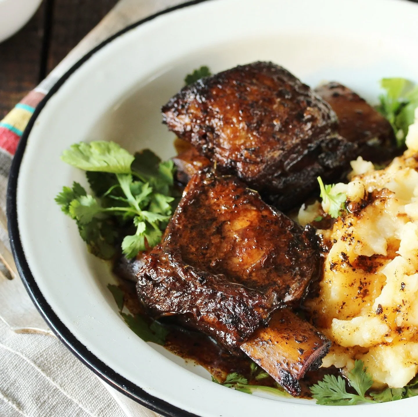 There&rsquo;s something deeply satisfying about a dish that transforms simple ingredients into something extraordinary with a bit of time. These wine-braised short ribs are precisely that&mdash;a study in how gentle heat and good wine can turn modest