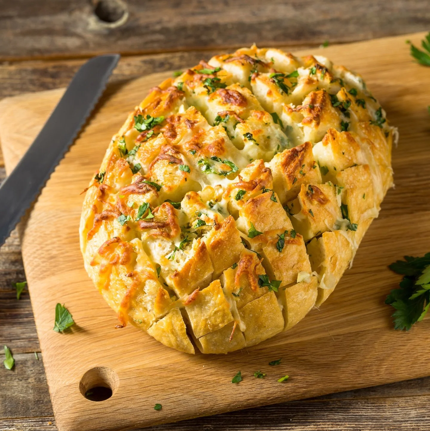 Bound to become one of your go-to recipes, this showstopping Cheesy Pull-Apart Bread looks complex but is surprisingly simple to make. The secret lies in the technique. A whole, unsliced round loaf is transformed into a stunning flower of pull-apart 