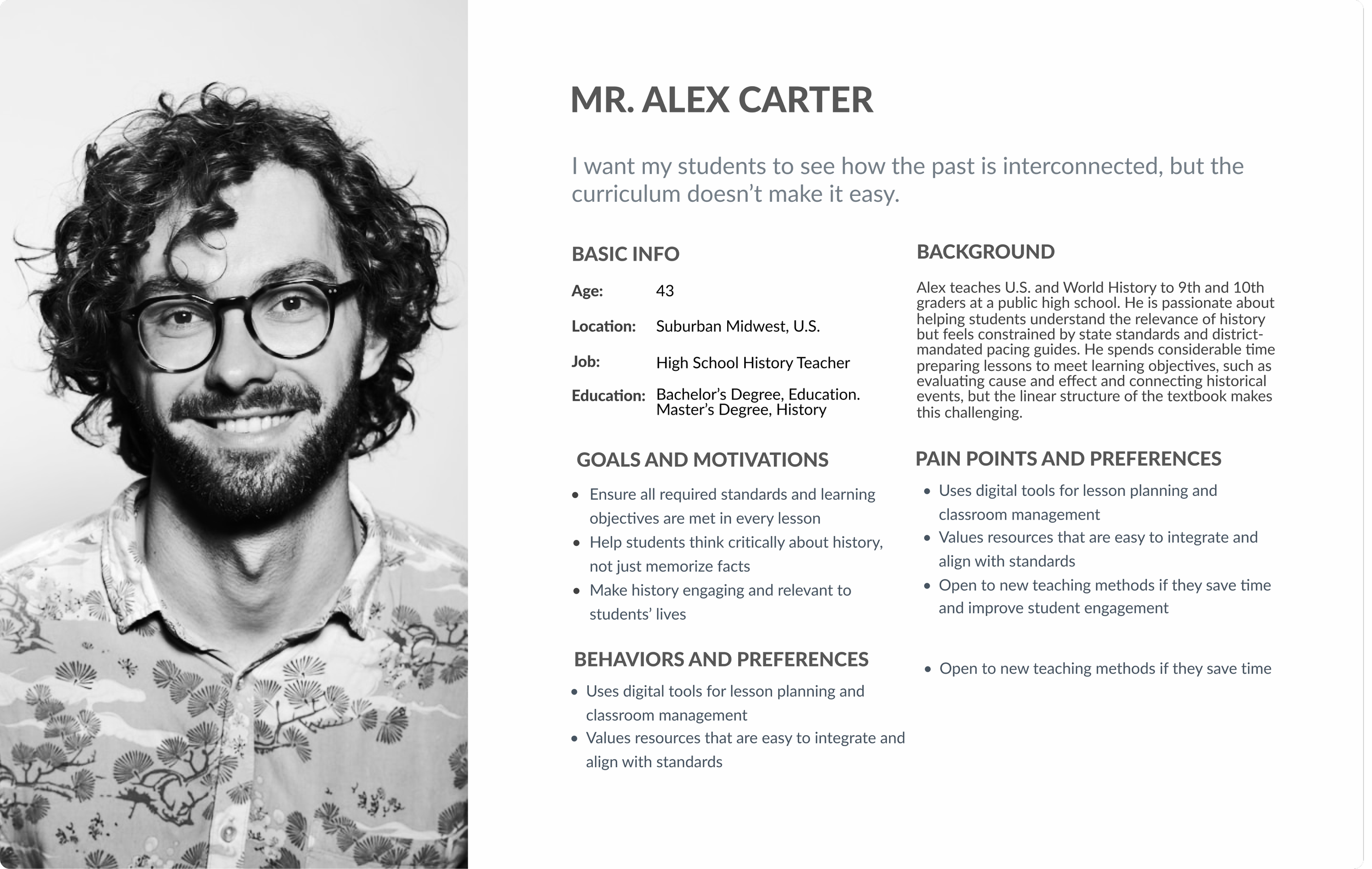 A black and white photo of a man with curly hair, glasses, a beard, and a floral patterned shirt, smiling.