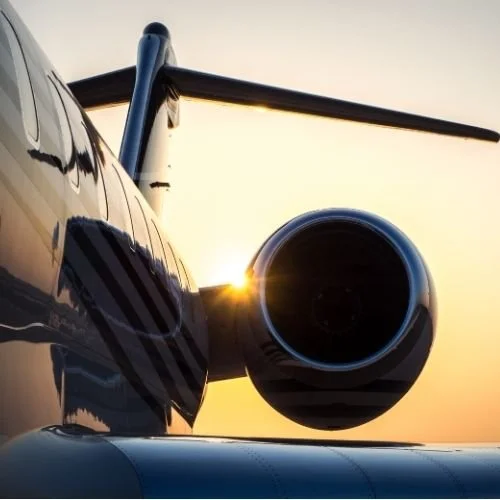 Close-up of a jet engine on an aircraft during sunset.