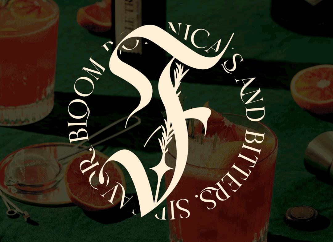 A glass of pink grapefruit juice with slices of grapefruit around it on a green surface, with bar tools and a logo overlay that says 'SAND BITCHERS' and 'F' in stylized font.