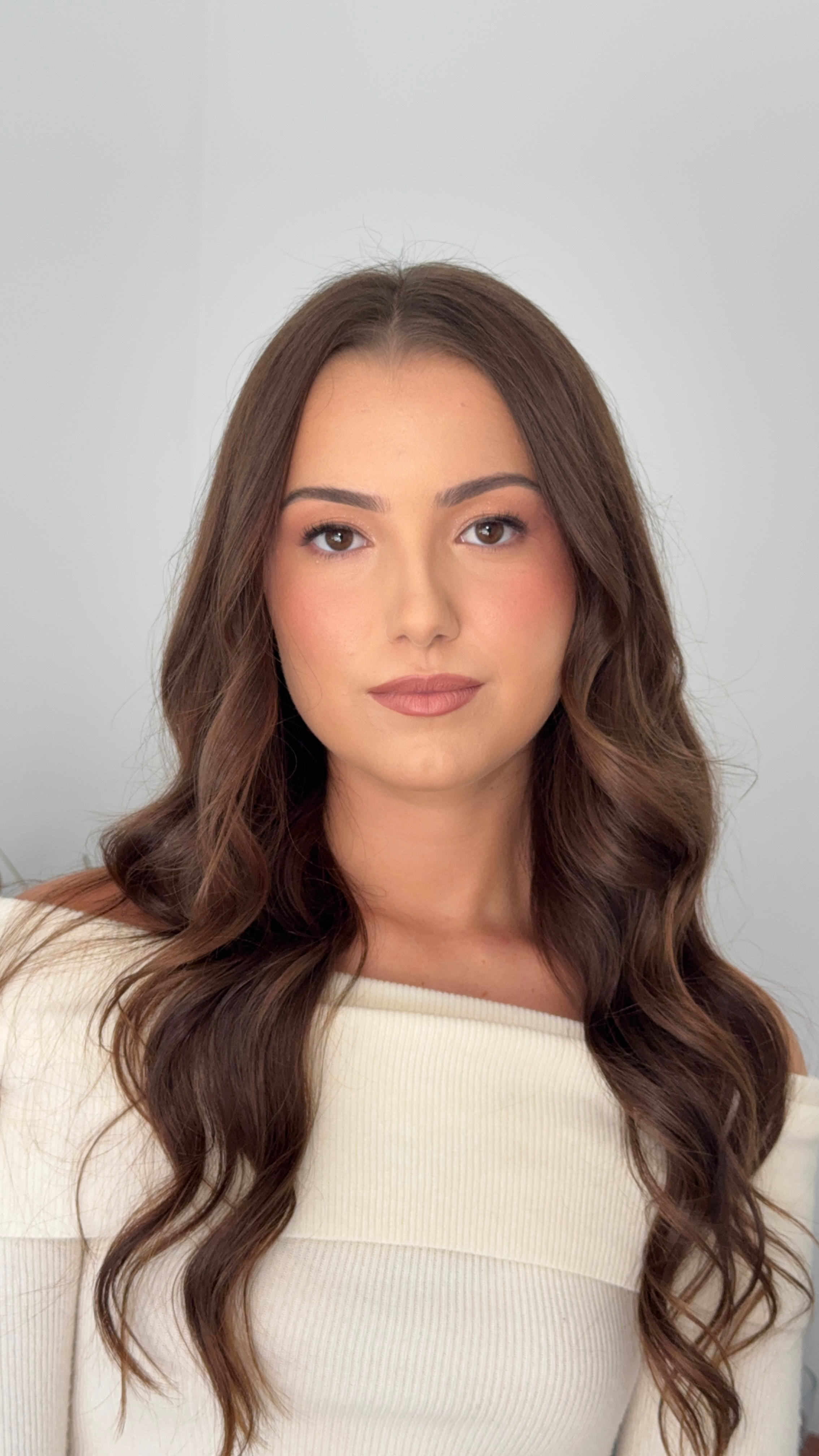 Soft glam makeup with minimal eyeshadow, glowy skin, and rosy pink blush.